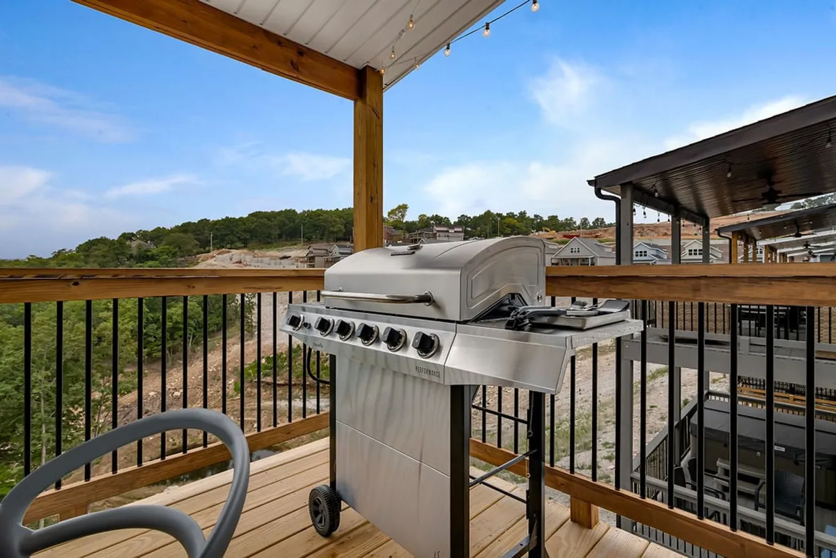 A casual outdoor grilling area on the deck, with a view of the landscape stretching beyond the railing. The grill setup and open space make it an inviting spot for outdoor dining, relaxing, and sharing stories after a walk or playtime.